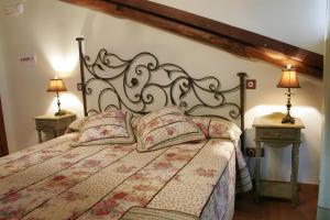 Un dormitorio con una cama grande con dos mesitas de noche. en Posada La Gatera, en Pedro Bernardo