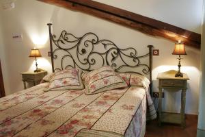 een slaapkamer met een groot bed met 2 nachtkastjes bij Posada La Gatera in Pedro Bernardo