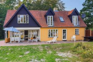 a yellow house with chairs and a table at 10081A-Rorvig-Skansehagevej-34 in Rørvig