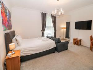 a bedroom with a bed and a couch and a television at Arkwright in Matlock