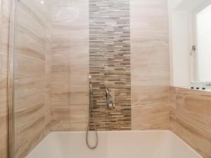 a bath tub in a bathroom with a shower at Arkwright in Matlock +10 photos
