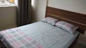 a bed with two pillows on it with a window at Lapa Dos Arcos in Rio de Janeiro