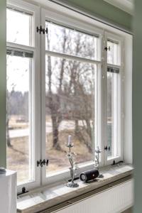 a window with a candle on a window sill at Nordic Calm Forest Apartment in Hävla