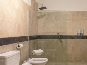a bathroom with a toilet and a glass shower at Refugio - Suite privada con jardín y parrilla en Chilecito in Chilecito +3 photos