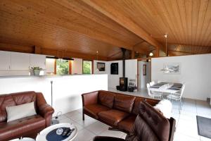 a living room with brown leather furniture and a table at 12253-Nykobing-Sj-Aeblehegnet-7 in Tjørneholm