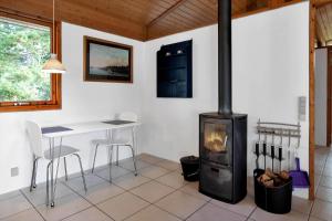 a living room with a stove and a table and chairs at 12253-Nykobing-Sj-Aeblehegnet-7 in Tjørneholm