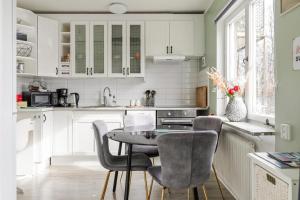 a kitchen with white cabinets and a table and chairs at Nordic Calm Forest Apartment in Hävla +37 photos