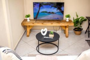 a living room with a tv and a table at Revitalize in Springs