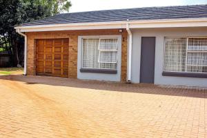 a house with a brown door and a brick driveway at Revitalize in Springs