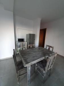 a wooden table and chairs in a room at Casas do Lourenço in São Roque do Pico +2 photos