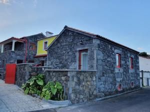 a stone house on the side of a street at Casas do Lourenço in São Roque do Pico