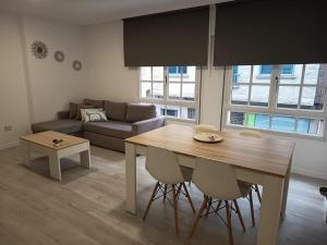 a living room with a table and a couch at Apartamentos Demar Luis Casais in O Grove