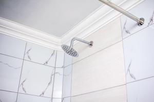 a shower in a bathroom with white tiles at Revitalize in Springs