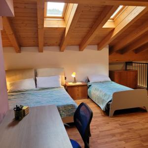 two beds in a room with wooden ceilings at Casa Gioia Alpina Mountain Lake Iseo Hospitality in Bossico