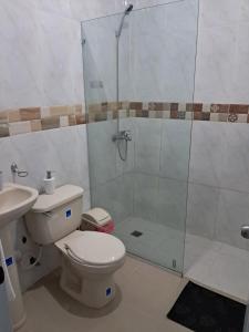 a bathroom with a toilet and a glass shower at Mario Aparta Estudio in San Felipe de Puerto Plata +29 photos