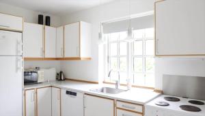 a kitchen with white cabinets and a sink and a window at 10098-Rorvig-Fjordvaenget-17 in Rørvig