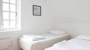 two beds in a room with a window at 10098-Rorvig-Fjordvaenget-17 in Rørvig