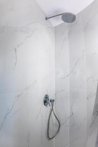 a bathroom with a shower with white marble walls at Mylos Design Suites in Perissa