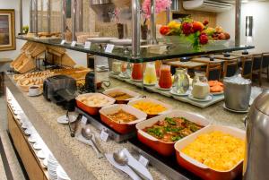 a buffet with many dishes of food on a counter at Hotel Bandeirantes in Rio de Janeiro