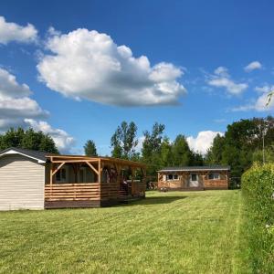 a house on a grass field next to a building at Domki na Mazurach "Malinka" in Suchy Róg