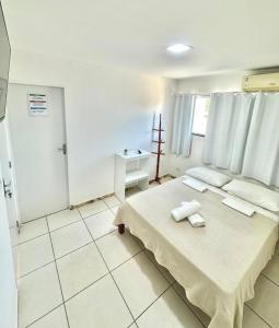 a bedroom with a bed with towels on it at Quarto 01 - Pousada Canaã in Recife