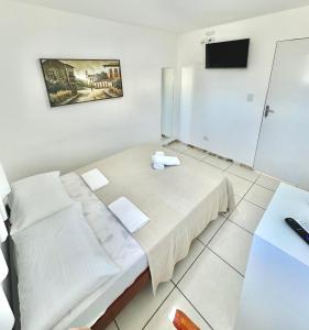 a room with a bed and a tv on the wall at Quarto 01 - Pousada Canaã in Recife