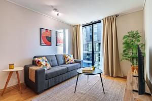 a living room with a couch and a tv at Nest Collection El Golf in Santiago