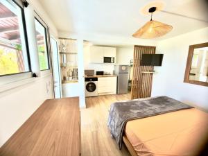 a small room with a bed and a kitchen at Sunset View - Panoramic Sea View - Deshaies in Deshaies