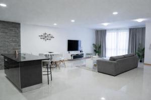 a white living room with a couch and a table at Salt & Sand T3 in Praia