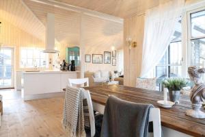 a kitchen and living room with a wooden table and chairs at 17716-Horve-Strandlunden-60 in Hørve