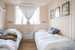 two beds in a room with a window at 17716-Horve-Strandlunden-60 in Hørve