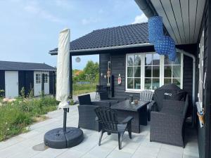 a patio with a table and chairs and an umbrella at 17716-Horve-Strandlunden-60 in Hørve