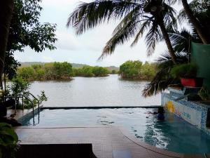 a swimming pool with a view of a river at Serene Waters Homestay Goa in Panaji