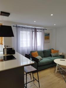 a living room with a green couch and a table at Pretodomar3 in A Coruña