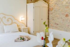 una camera da letto con un letto bianco e asciugamani di Casa Leon d'Oro a Bosco Chiesanuova
