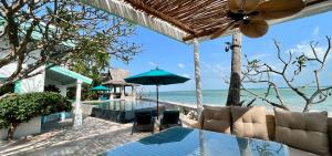 an outdoor dining area with a view of the ocean at Villa Sunrise - Golden Beachfront in Nathon Bay
