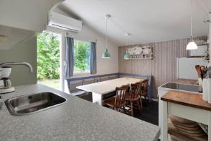 a kitchen with a sink and a table with chairs at 13360-1-Asnaes-Mejsevej-6 in Asnæs