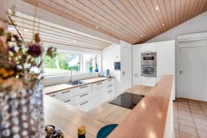 a kitchen with white cabinets and a wooden ceiling at 14233-Grevinge-Grevinge-Kanalvej-95 in Grevinge