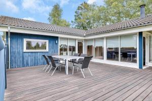 a deck with a table and chairs on a house at 14233-Grevinge-Grevinge-Kanalvej-95 in Grevinge