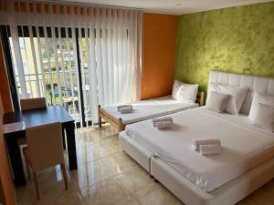a bedroom with two beds and a desk and a table at Bonavita Zaton in Zaton