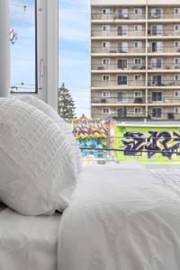 a bed with a white pillow in front of a window at Stylish Serenity 1BR Kensington Condo wParking in Calgary