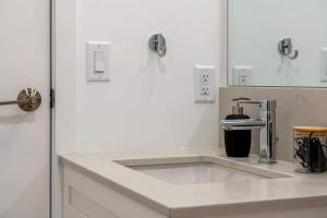 a bathroom with a sink and a faucet at Exquisite 2 Bed Condo near DT Core WFree Parking in Calgary +33 photos