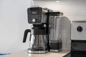 a coffee maker with a cell phone on top of it at Exquisite 2 Bed Condo near DT Core WFree Parking in Calgary