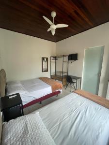a bedroom with two beds and a ceiling fan at Pousada 4 Estações in Canoinhas