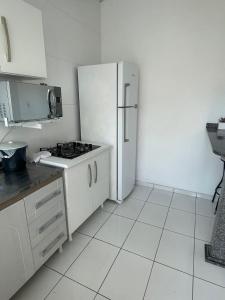a kitchen with a white refrigerator and a white tile floor at Pousada 4 Estações in Canoinhas +37 photos