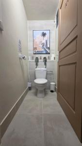 a bathroom with a toilet and a painting on the wall at Villa Maxime in Sainte-Marie