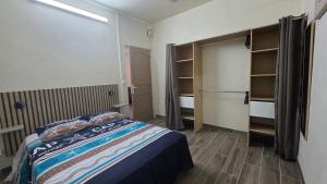 a bedroom with a bed and a closet at Villa Maxime in Sainte-Marie