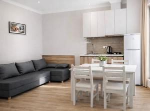 a kitchen and living room with a table and a couch at Fortuna Cottage Bakuriani in Bakuriani