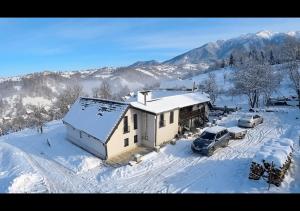 a house in the snow with cars parked in it at Festung 57 in Bran