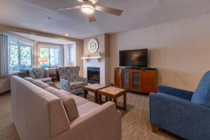 a living room with a couch and chairs and a tv at San Clemente Cove Resort in San Clemente